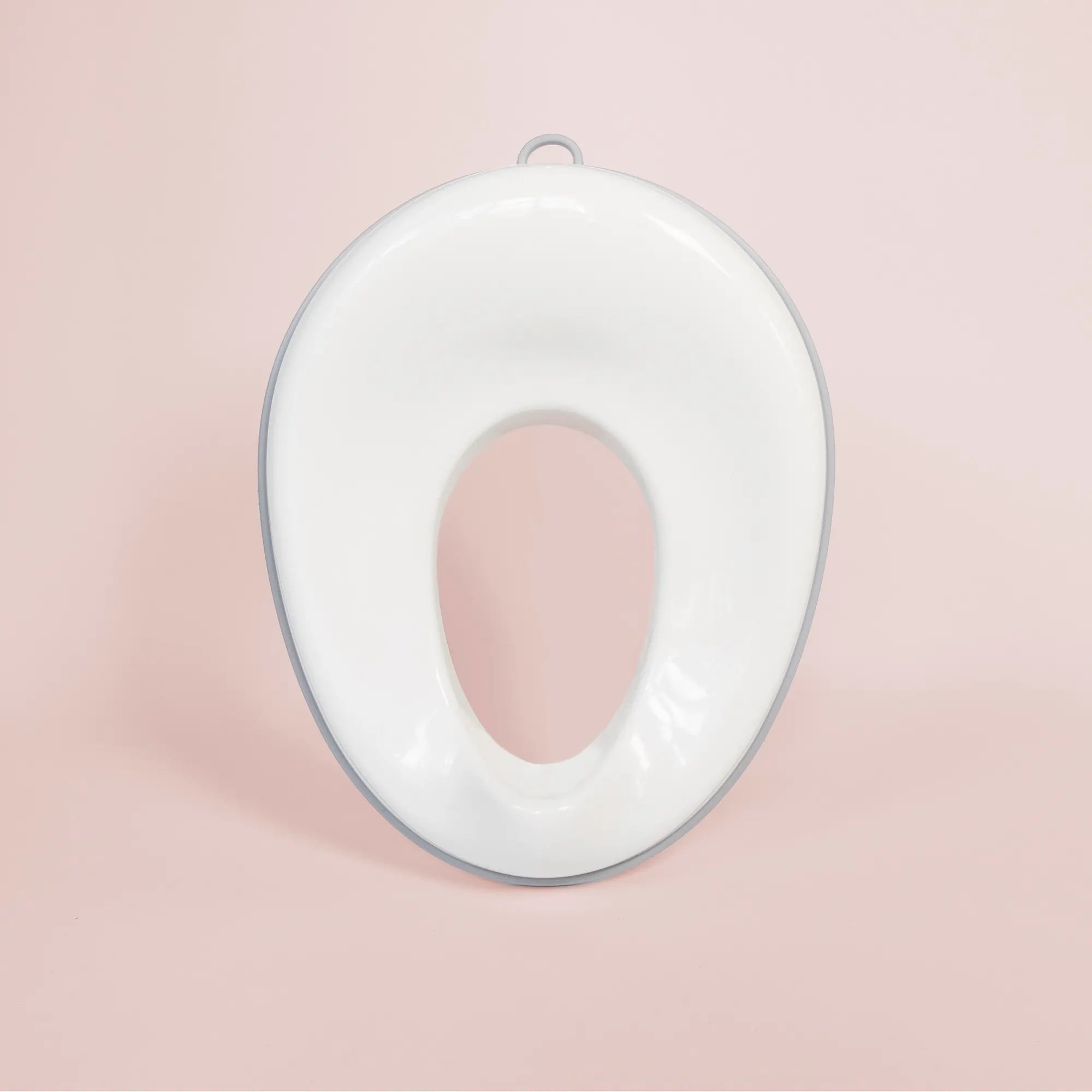 Toalettsits för barn i vit plast med silikongrepp och stänkskydd.